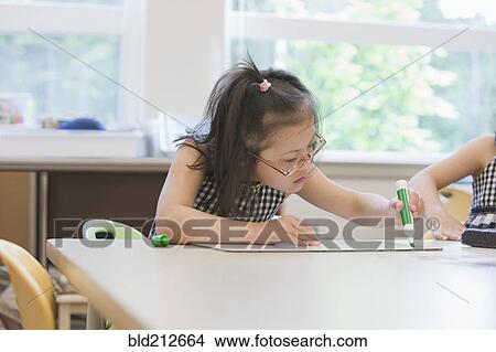 Picture - Mixed race Down syndrome students drawing in class. Fotosearch