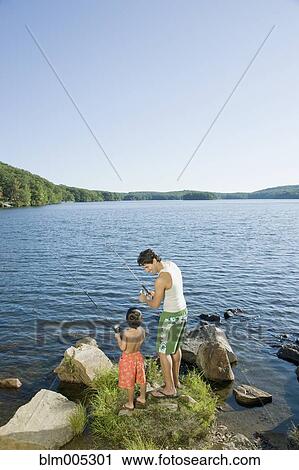 Mixed race father and son fishing in lake View Large Photo Image Stock Image - Mixed race father and son fishing in lake. Fotosearch
