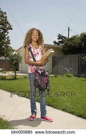 Stock Photography - Mixed race girl carrying books. Fotosearch