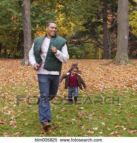 Mixed race girl chasing father in park View Large Photo Image Stock Photography - Mixed race girl chasing father in park. Fotosearch