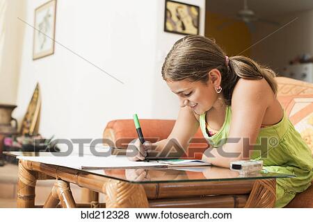 Stock Photo - Mixed race girl coloring at desk. Fotosearch