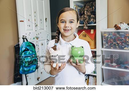 Stock Photo - Mixed race girl holding toy animals. Fotosearch