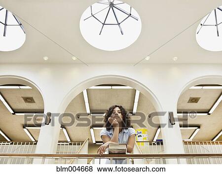 Mixed race girl leaning on railing in library View Large Photo Image Stock Photo - Mixed race girl leaning on railing in library. Fotosearch