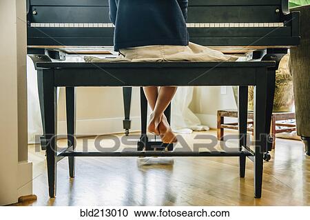 Stock Image - Mixed race girl playing piano. Fotosearch