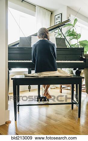 Stock Photo - Mixed race girl playing piano. Fotosearch