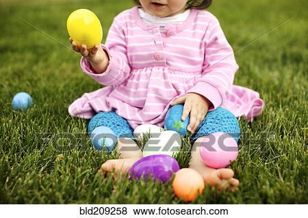 Mixed race girl playing with Easter eggs View Large Photo Image Stock Photo - Mixed race girl playing with Easter eggs. Fotosearch