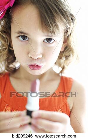 Stock Photograph - Mixed race girl playing with lipstick. Fotosearch