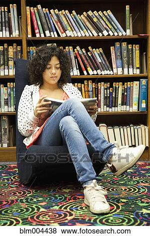 Stock Photo - Mixed race girl studying in library. Fotosearch