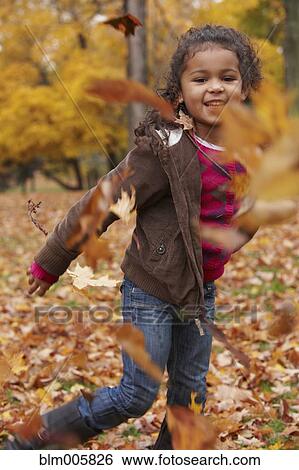 Mixed race girl throwing autumn leaves View Large Photo Image Stock Photograph - Mixed race girl throwing autumn leaves. Fotosearch