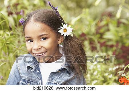 Stock Photograph - Mixed race girl wearing flowers in her hair. Fotosearch