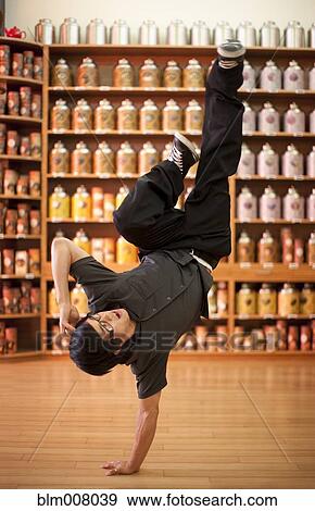 Mixed race man doing handstand in shop View Large Photo Image Stock Photo - Mixed race man doing handstand in shop. Fotosearch