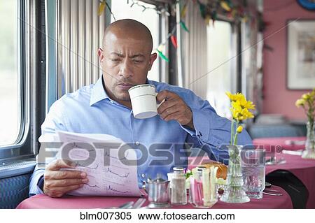 Mixed race man eating in diner and reading paperwork View Large Photo Image Stock Photography - Mixed race man eating in diner and reading paperwork. Fotosearch