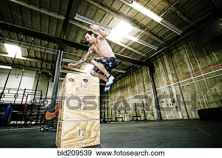 Stock Photo - Mixed race man exercising in gym. Fotosearch
