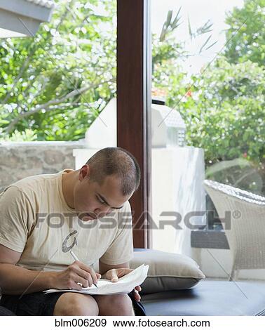 Stock Photo - Mixed race man filling out forms. Fotosearch
