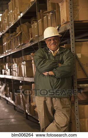 Mixed race man in hard-hat in warehouse View Large Photo Image Picture - Mixed race man in hard-hat in warehouse. Fotosearch
