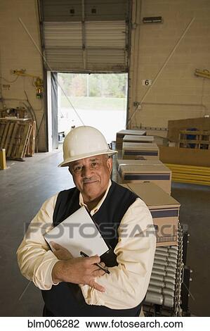 Mixed race man in hard-hat in warehouse View Large Photo Image Stock Image - Mixed race man in hard-hat in warehouse. Fotosearch