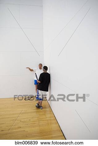 Mixed race man in racquetball court talking to friend View Large Photo Image Stock Photo - Mixed race man in racquetball court talking to friend. Fotosearch