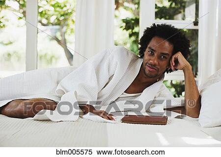 Mixed race man laying on bed reading View Large Photo Image Stock Photography - Mixed race man laying on bed reading. Fotosearch