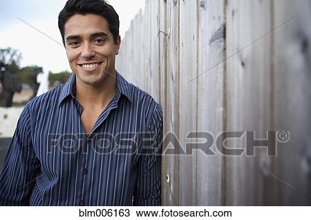 Mixed race man leaning against fence View Large Photo Image Stock Image - Mixed race man leaning against fence. Fotosearch