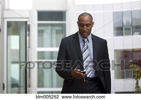 Mixed race man looking at cell phone View Large Photo Image Stock Image - Mixed race man looking at cell phone. Fotosearch