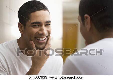Mixed race man looking at reflection View Large Photo Image Stock Image - Mixed race man looking at reflection. Fotosearch