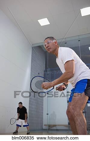 Stock Photography - Mixed race man playing racquetball. Fotosearch