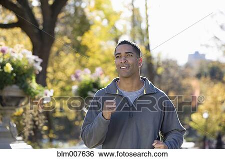 Mixed race man running in park View Large Photo Image Stock Photograph - Mixed race man running in park. Fotosearch
