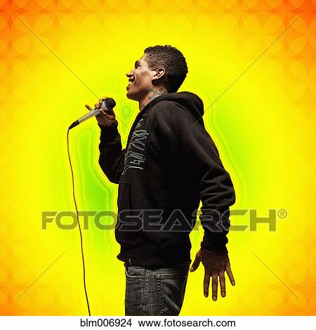 Picture - Mixed race man singing into microphone. Fotosearch