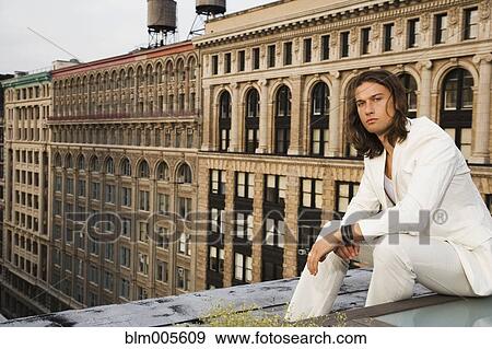 Mixed race man sitting on urban rooftop View Large Photo Image Stock Photo - Mixed race man sitting on urban rooftop. Fotosearch
