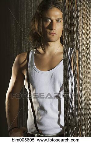 Mixed race man standing by chain curtain View Large Photo Image Stock Photography - Mixed race man standing by chain curtain. Fotosearch