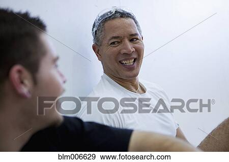 Stock Photo - Mixed race man talking to friend. Fotosearch