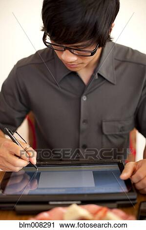 Mixed race man using digital tablet View Large Photo Image Stock Image - Mixed race man using digital tablet. Fotosearch
