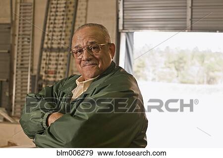 Mixed race man with arms crossed in warehouse View Large Photo Image Stock Photo - Mixed race man with arms crossed in warehouse. Fotosearch