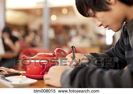 Mixed race man writing at cafe View Large Photo Image Stock Photography - Mixed race man writing at cafe. Fotosearch