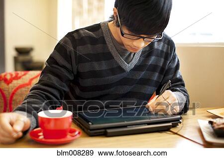 Mixed race man writing on digital tablet View Large Photo Image Stock Photo - Mixed race man writing on digital tablet. Fotosearch