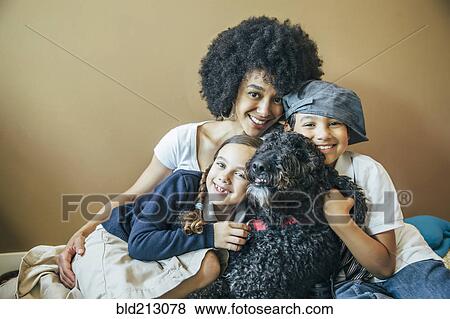 Mixed race mother and children hugging dog View Large Photo Image Stock Photo - Mixed race mother and children hugging dog. Fotosearch