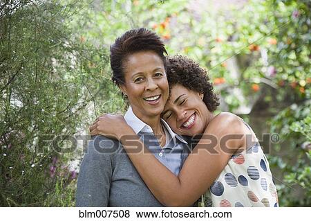 Mixed race mother and daughter hugging View Large Photo Image Stock Photo - Mixed race mother and daughter hugging. Fotosearch