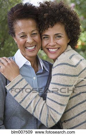 Mixed race mother and daughter hugging View Large Photo Image Stock Photo - Mixed race mother and daughter hugging. Fotosearch