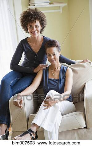 Mixed race mother and daughter sitting in armchair View Large Photo Image Stock Image - Mixed race mother and daughter sitting in armchair. Fotosearch
