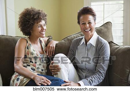 Mixed race mother and daughter sitting on sofa View Large Photo Image Stock Photography - Mixed race mother and daughter sitting on sofa. Fotosearch