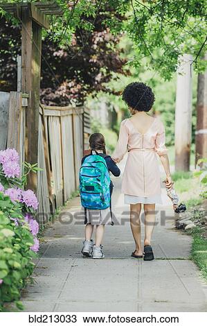 Mixed race mother and daughter walking on suburban sidewalk View Large Photo Image Stock Image - Mixed race mother and daughter walking on suburban sidewalk. Fotosearch