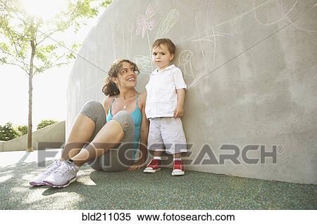 Stock Photography - Mixed race mother sitting with son outdoors. Fotosearch