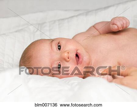 Stock Photograph - Mixed race newborn baby laying in crib. Fotosearch