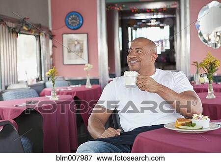 Stock Photo - Mixed race waiter eating food in restaurant. Fotosearch