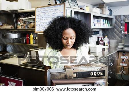 Mixed race waitress at cash register in diner View Large Photo Image Stock Photograph - Mixed race waitress at cash register in diner. Fotosearch