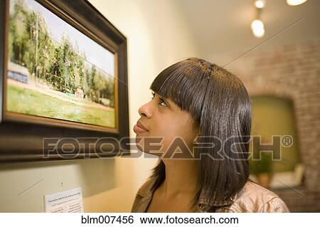 Mixed race woman admiring painting in gallery View Large Photo Image Stock Photograph - Mixed race woman admiring painting in gallery. Fotosearch
