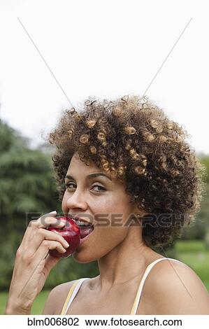Mixed race woman eating apple View Large Photo Image Stock Image - Mixed race woman eating apple. Fotosearch