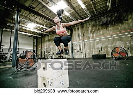 Stock Photo - Mixed race woman exercising in gym. Fotosearch