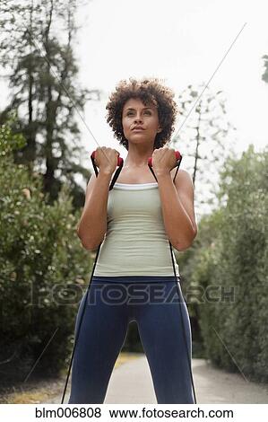 Mixed race woman exercising in park View Large Photo Image Stock Photo - Mixed race woman exercising in park. Fotosearch