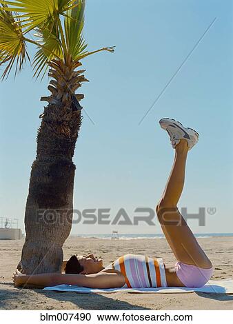 Mixed race woman exercising on beach View Large Photo Image Stock Image - Mixed race woman exercising on beach. Fotosearch